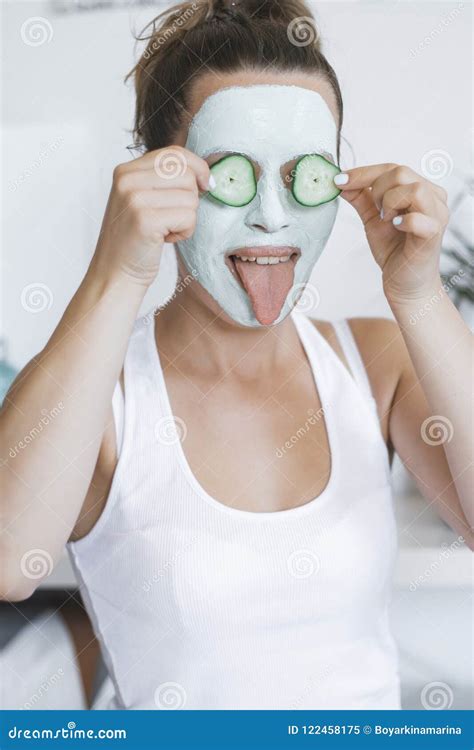 Femme Assez Blonde De Jeunes Avec Le Masque Facial Posant Avec Le Concombre Image Stock Image