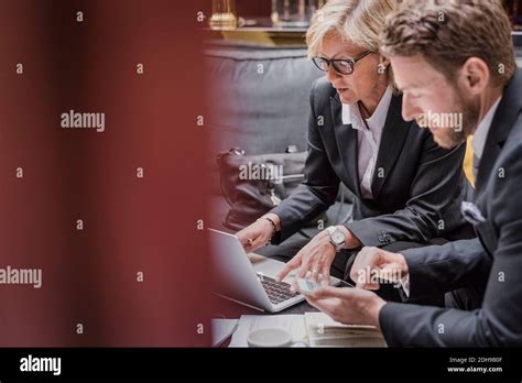 Business People Using Laptop And Mobile Phone During Meeting In Hotel