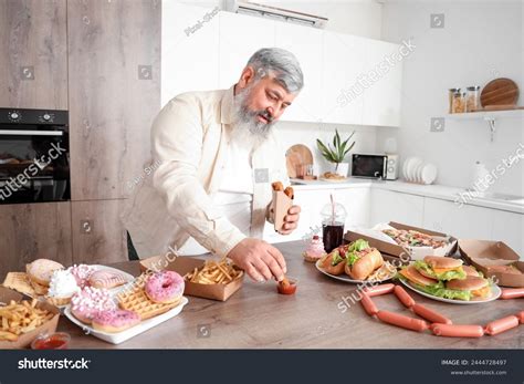 Стоковая фотография 2444728497 Overweight Mature Man Table Full