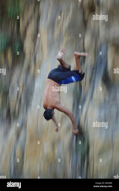 Boy jumping off a cliff into water, Puerto Varrarta Stock Photo - Alamy