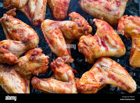 Spicy Marinated Chicken Wings Grilling On A Summer Barbecue With Hot Flames In A Close Up View