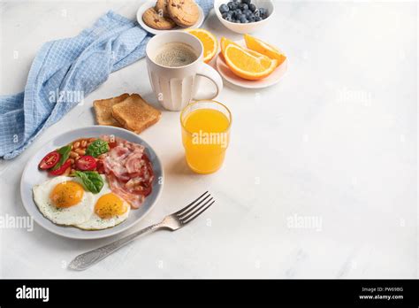 Breakfast With Fried Eggs Bacon Orange Juice Yogurt And Toasts Top