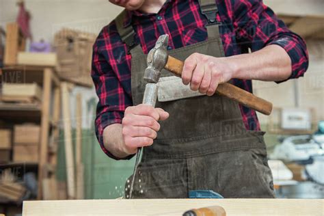 Carpenter Working With A Chisel And Hammer In A Wooden Workshop