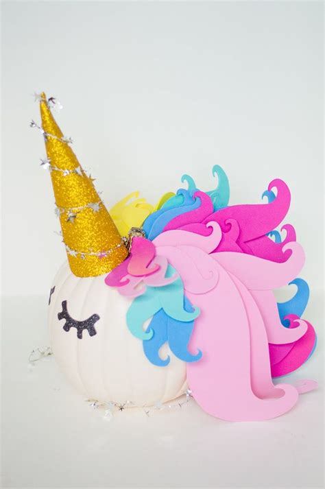 A White Pumpkin Decorated With Pink Blue And Yellow Unicorns On It S Head