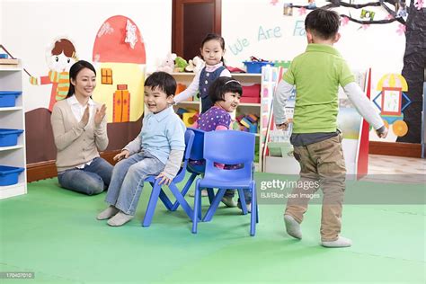 Happy Kindergarten Children Playing Musical Chairs High-Res Stock Photo