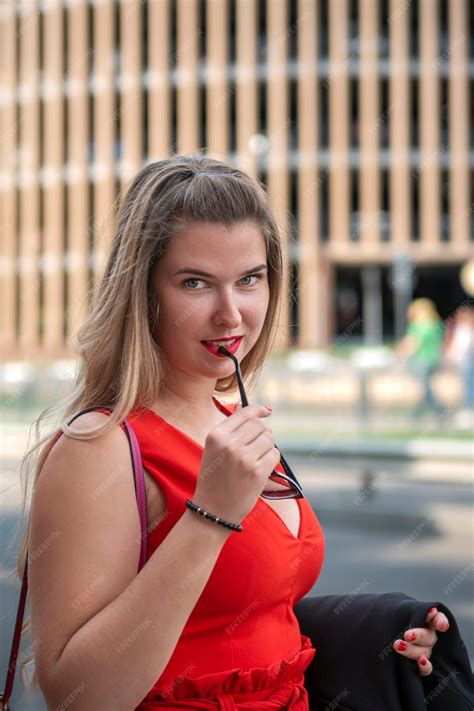 Premium Photo Attractive Blonde Girl In Red Dress With Glasses In Her