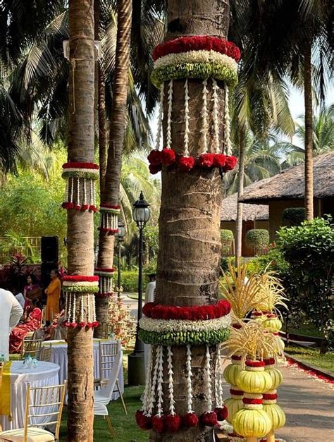 An Outdoor Area With Palm Trees Flowers And Decorations On The Tables