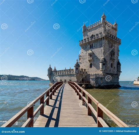 Scenic Belem Tower And Wooden Bridge Miroring With Low Tides On Tagus