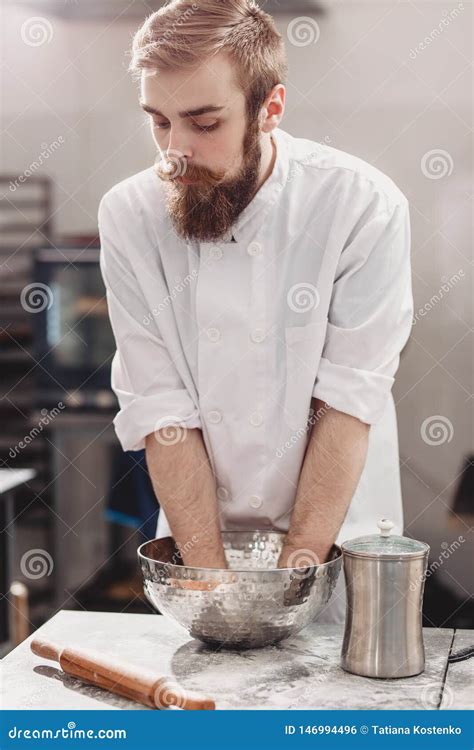 Professional Baker Kneads Dough In An Iron Bowl On The Table In The Kitchen Of The Bakery Stock