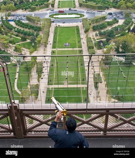 Tourist Looking Through Telescope From Eiffel Tower Observation