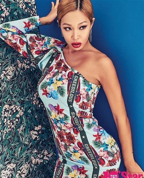 A Woman In A Floral Print Dress Leaning Against A Wall With Her Hands