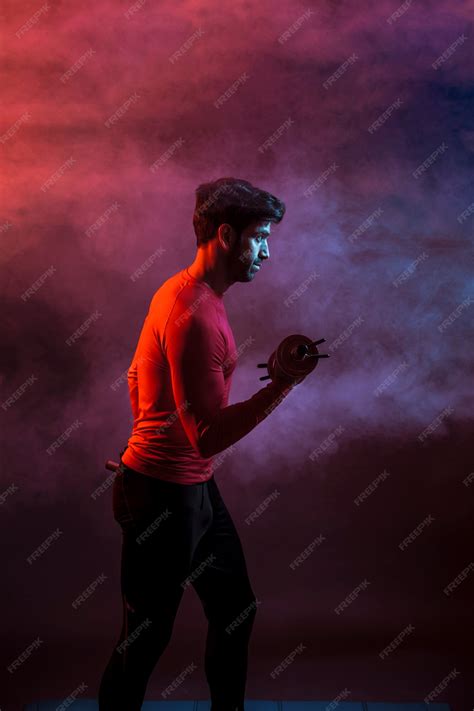 Free Photo | Confident athlete with weight in dark
