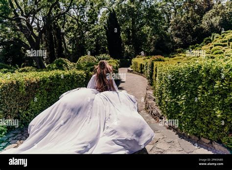 Brunette Runs White Dress Park A Beautiful Woman With Long Brown Hair And A Long White Dress