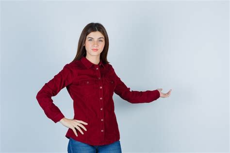 Free Photo | Girl showing welcoming gesture in burgundy shirt and ...
