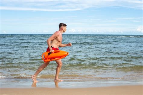 Voller Schuss Rettungsschwimmer L Uft Am Strand Kostenlose Foto