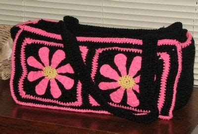 A Pink And Black Crocheted Bag Sitting On Top Of A Wooden Table Next To