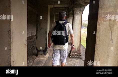 Man Sightseeing Ancient Angkor Wat Complex Temple Ruins In Cambodia