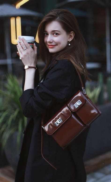 A Woman Holding A Coffee Cup In Her Right Hand