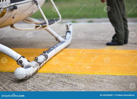 Helicopter Landing Skids On Helipad And Pilot Backgroun Stock Photo
