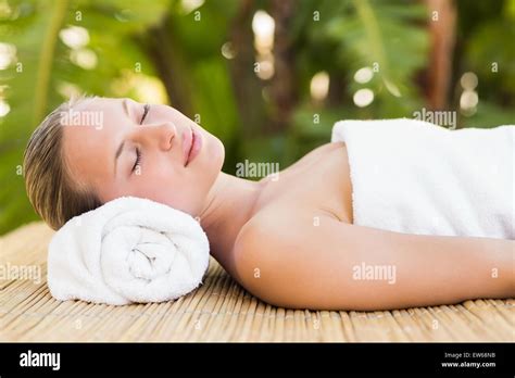 Peaceful Blonde Lying On Bamboo Mat With Flowers Stock Photo Alamy