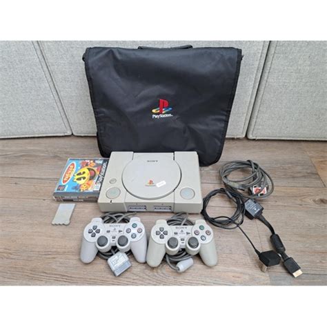 A Sony Playstation Scph Console With Two Controllers Games And