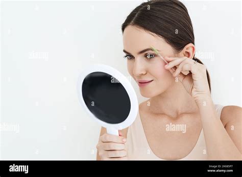 Beautiful Woman Combing Her Eyebrows With Brush Tool While Looking Into