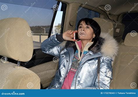 Worried Scared Woman Passenger Sitting On Back Seat Of Car Talking On Mobile Phone She Is