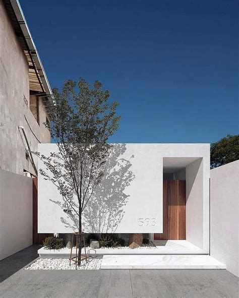 A White Building With A Tree In Front Of It