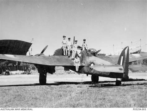 Informal Group Portrait Of RAAF Members Standing On The Wing Of A DAP