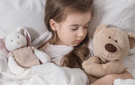 Mignonne Petite Fille Au Lit Avec Peluche Photo Gratuite