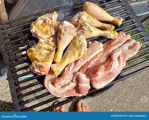 Corn Fed Chicken Thighs And Drumsticks With Outdoor Pork Belly Prepared On A Charcoal Grill