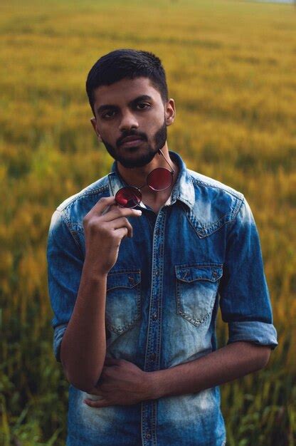 Premium Photo Portrait Of Young Man Standing On Field