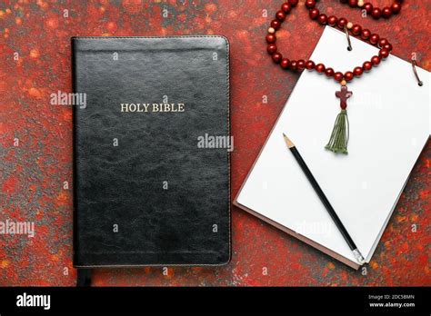Hole Bible Notebook And Rosary Beads On Color Background Stock Photo