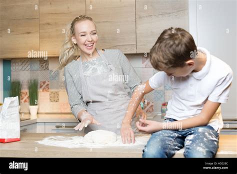 Mother And Son Playing In Kitchen With Flour Flour Fight Stock Photo