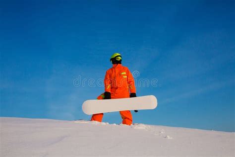 Snowboarder Freerider With White Snowboard Standing On The Top Of The