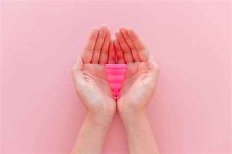 Copo Menstrual Nas M Os De Uma Mulher Em Um Fundo Rosa Em Vista Plana