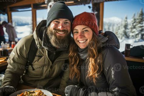 Couples Snowshoeing In Winter Gear Pausing For Hot Drinks And Toasted Sandwiches 32741624 Stock