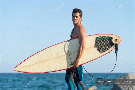 Man With Surfboard Standing On Coast Leisure Athlete Stock Photo