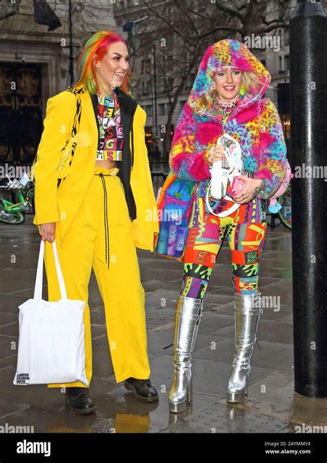 Fashionistas dressed in colourful outfits pose for a photo outside the ...