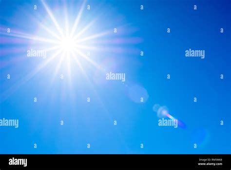 Blue sky and sun with flare Stock Photo - Alamy