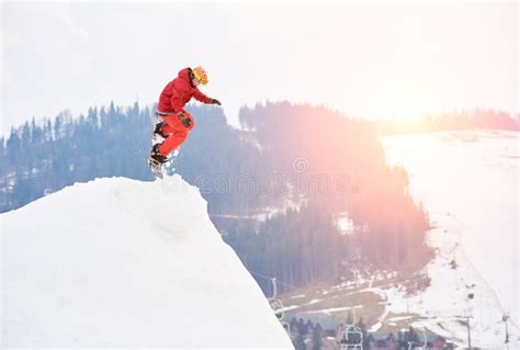 Man Snowboarder Jumping From The Top Of The Snowy Hill With Snowboard