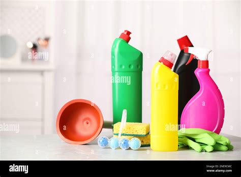 Different Toilet Cleaning Supplies And Tools On Light Grey Table