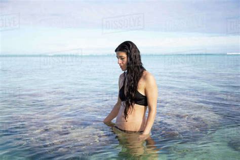 Woman In A Black Bikini Standing In Shallow Sea Water Under A Clear Sky Titikaveka Rarotonga