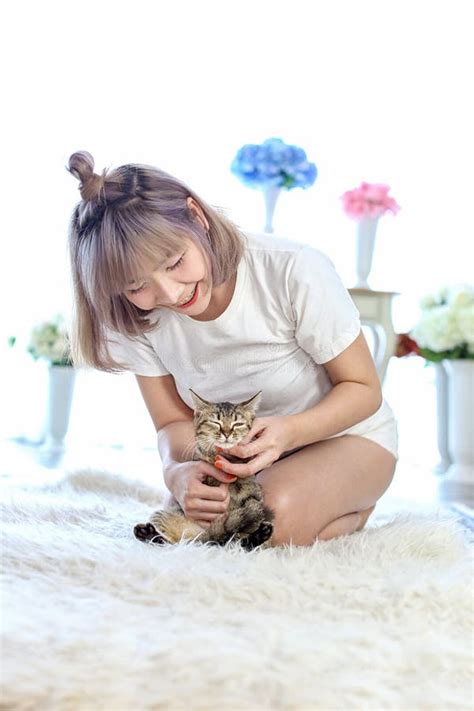 El Gato En El Abrazo De La Mujer Que Miente En La Alfombra De Las Lanas