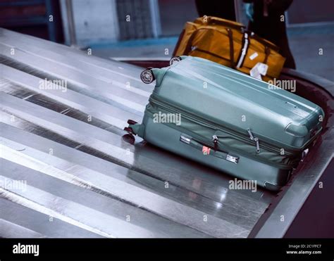 Suitcase On Luggage Conveyor Belt At Baggage Claim Area At Airport