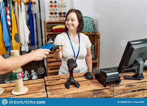 Brunette Woman With Down Syndrome Working As Shop Assistant Taking