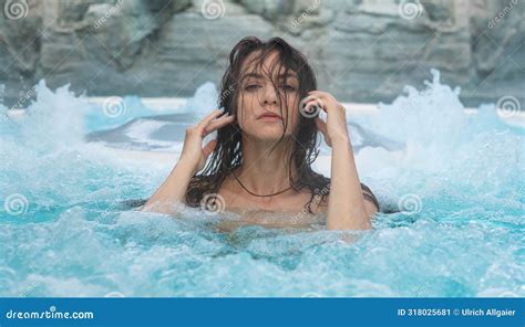 Portrait Of A Sensually Seductive Brunette Wet Woman In Turquoise Bubbling Foamy Water At The