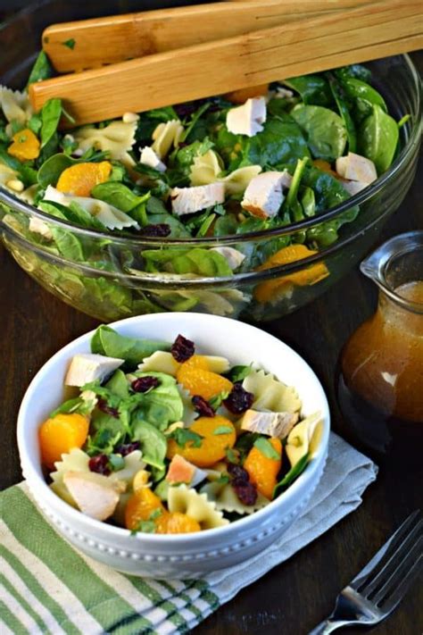 A Salad In A Bowl With Dressing Next To It