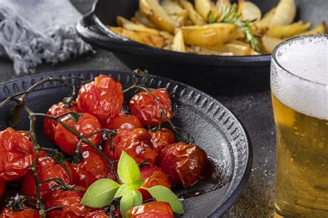 Plato De Tomates Confitados Y Patatas Asadas Con Romero En Cazuela De