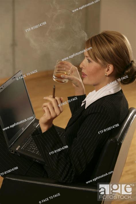 A Blonde Businesswoman Smoking And Drinking With A Laptop On Her Lap Stock Photo Picture And